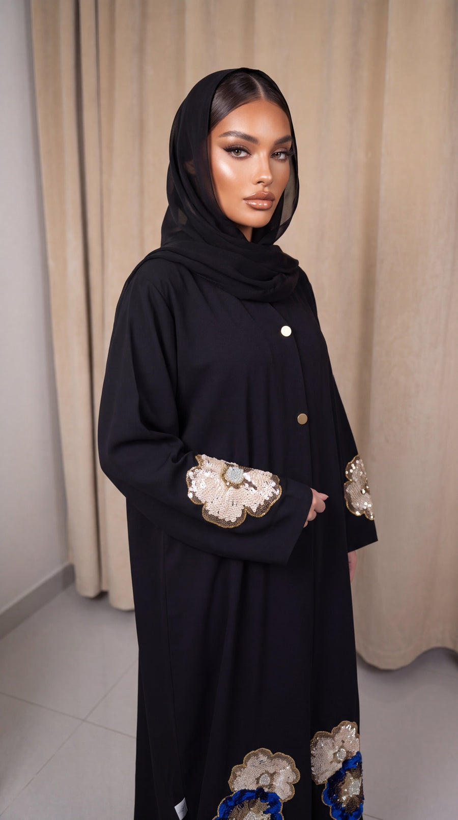 Sadil black abaya with gold and blue sequin floral sleeve embellishments and metallic button front closure